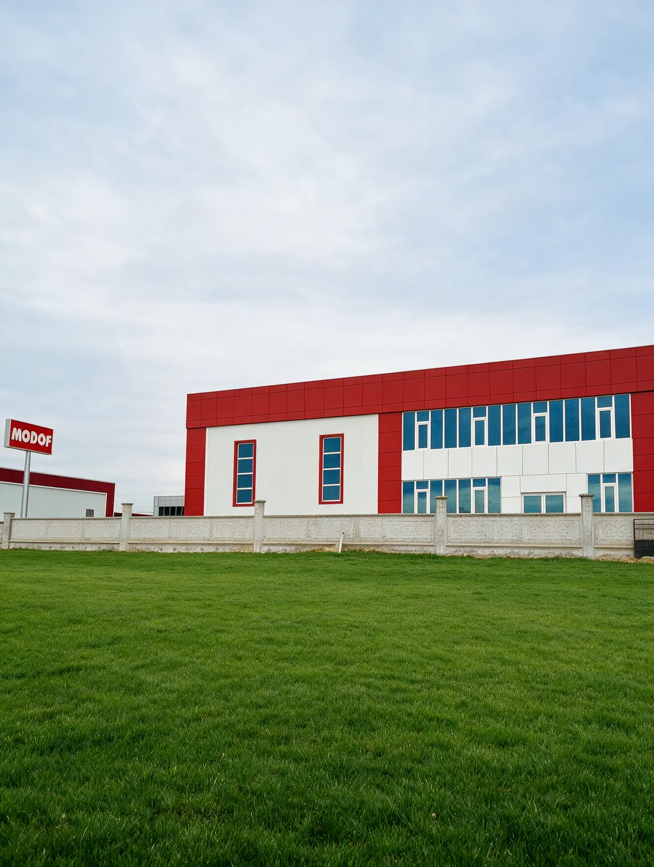Modof Mutfak üretim tesisi: kırmızı ve beyaz cepheli fabrika binası ve Modof tabelası